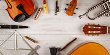 Instrumente und Notenständer liegen im Kreis vor Holzpaneelwand
